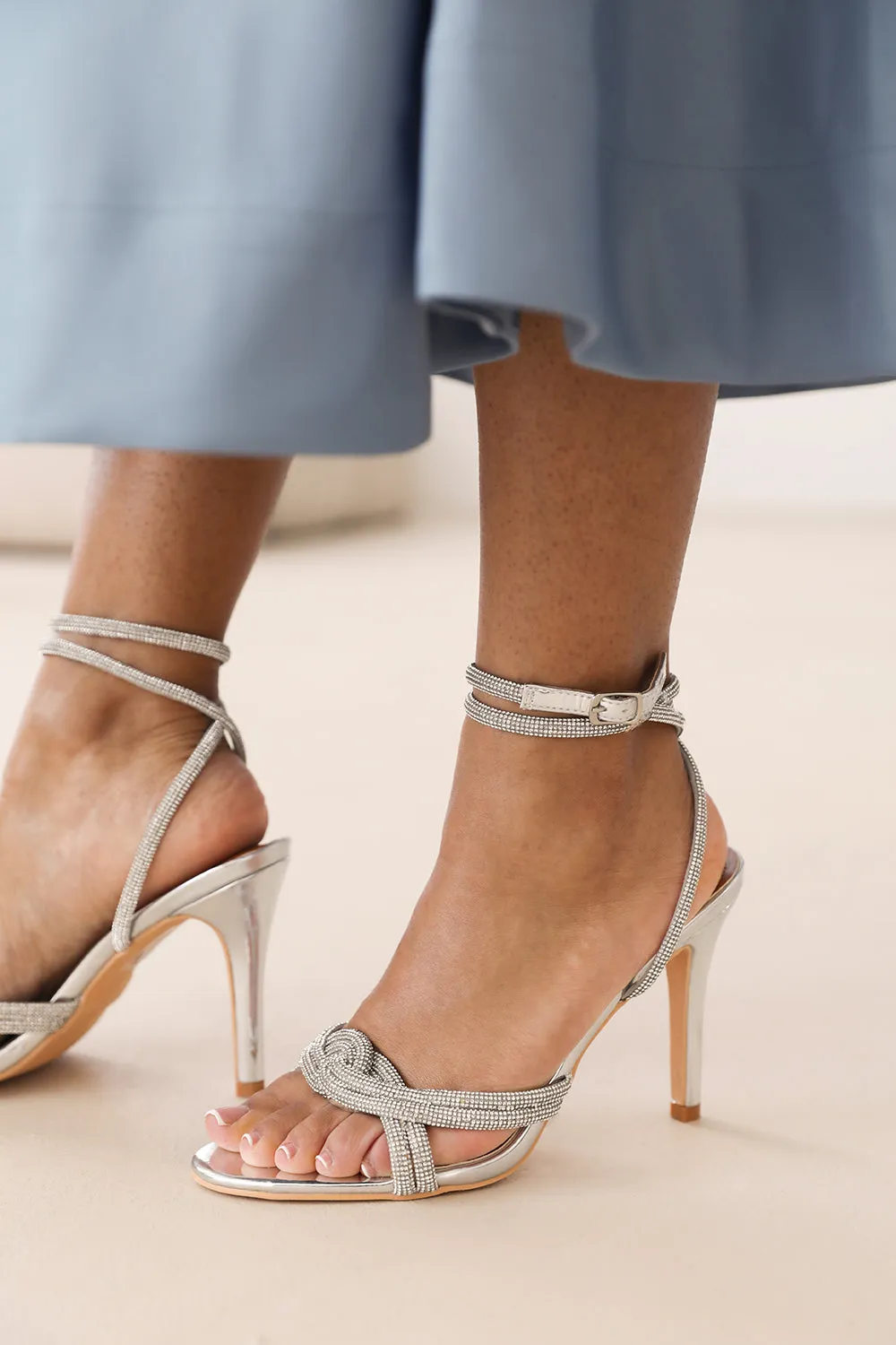 MADON DIAMANTE KNOT DETAIL WITH CROSS OVER ANKLE STRAP HIGH HEELS IN SILVER CHROME